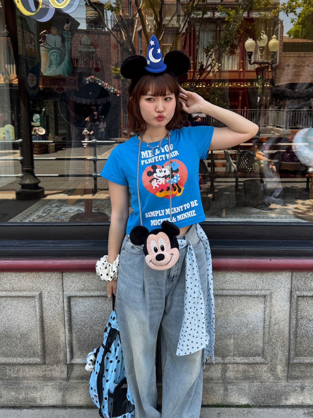 ブルー系のデニムパンツ、ブルー系のバックパック/リュック、ブラック系のローファーを着用したレディースの春コーディネートの2枚目の写真