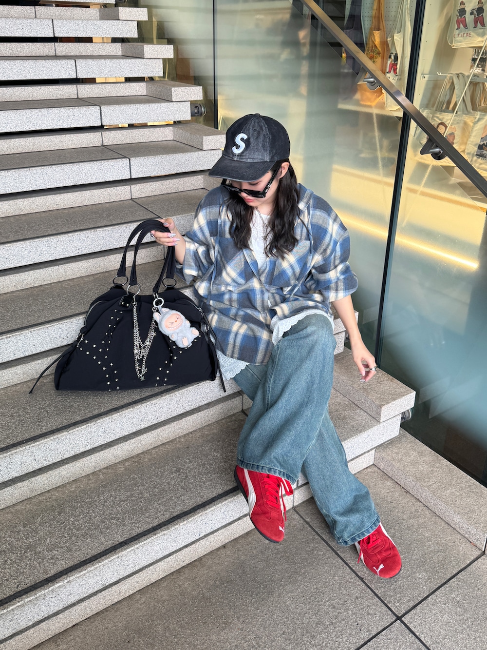 ブラック系のトートバッグ、ブルー系のシャツ/ブラウス、ブルー系のデニムパンツを着用したレディースの秋コーディネートの2枚目の写真