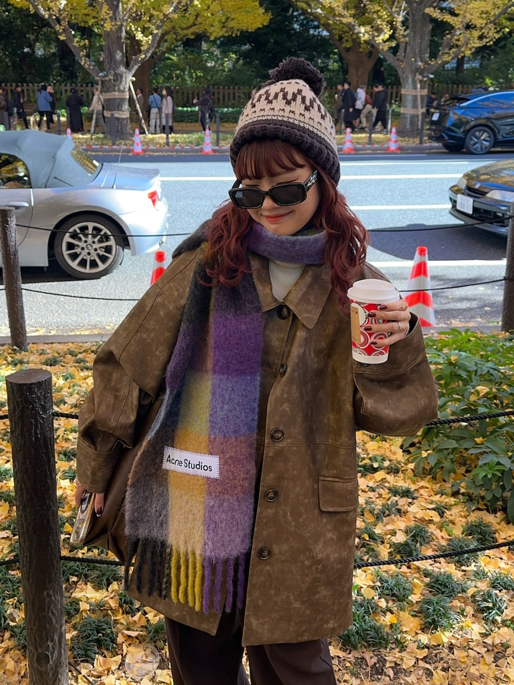 ブラウン系のその他アウター、ブラウン系のスラックス、ブラウン系のマフラーを着用したレディースの冬コーディネートの2枚目の写真