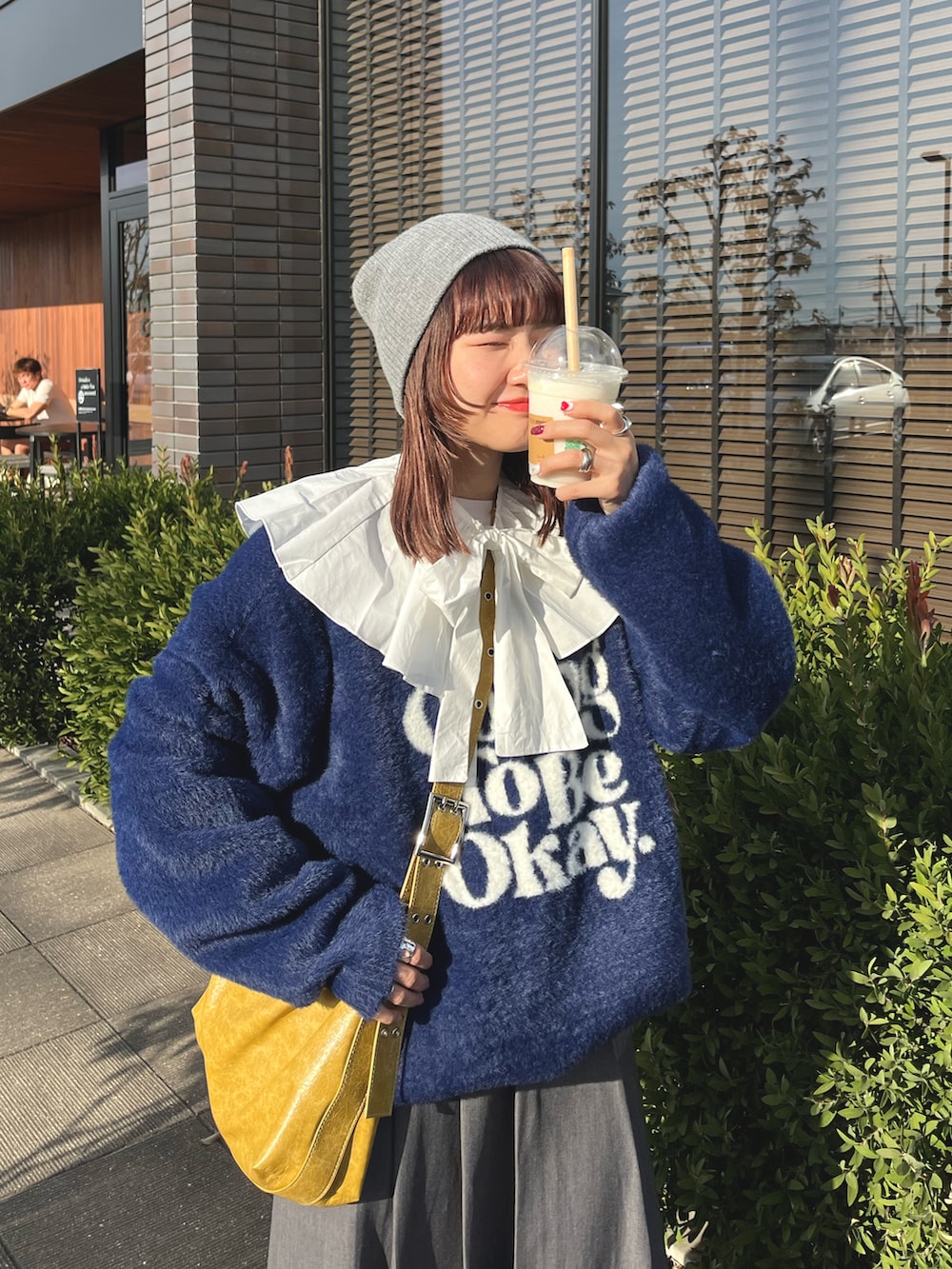 ブルー系のニット/セーター、イエロー系のショルダーバッグ、イエロー系のスニーカーを着用したレディースの冬コーディネートの2枚目の写真