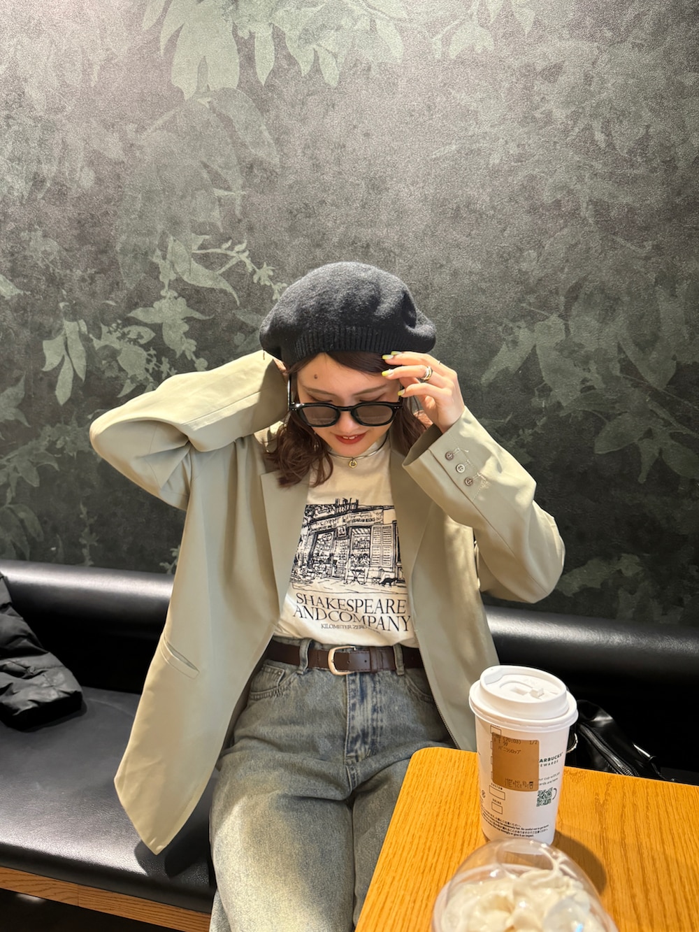 ブルー系のデニムパンツ、ベージュ系のテーラードジャケット、ブラック系のハンチング/ベレー帽を着用したレディースの春コーディネートの2枚目の写真