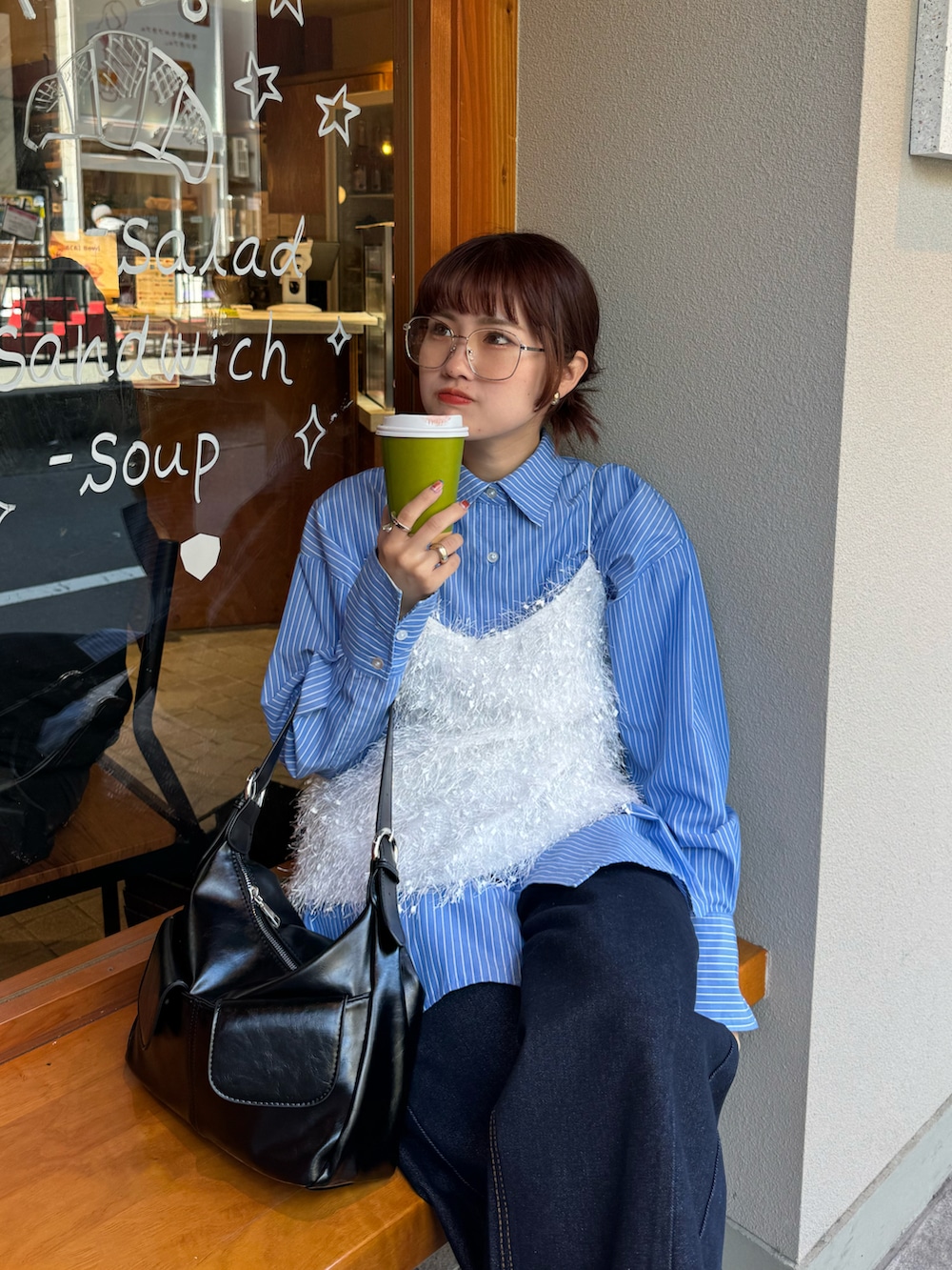 ブルー系のデニムパンツ、グレー系のスニーカー、ブルー系のシャツ/ブラウスを着用したレディースの春コーディネートの2枚目の写真