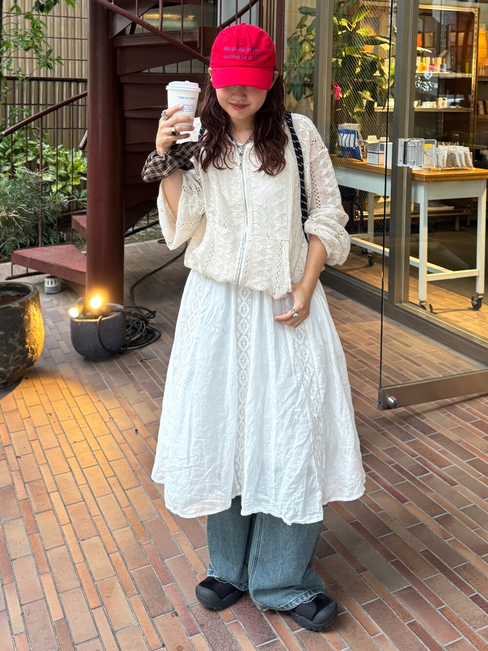 ホワイト系のパーカー、ホワイト系のワンピース、ブルー系のデニムパンツを着用したレディースの夏コーディネートの2枚目の写真