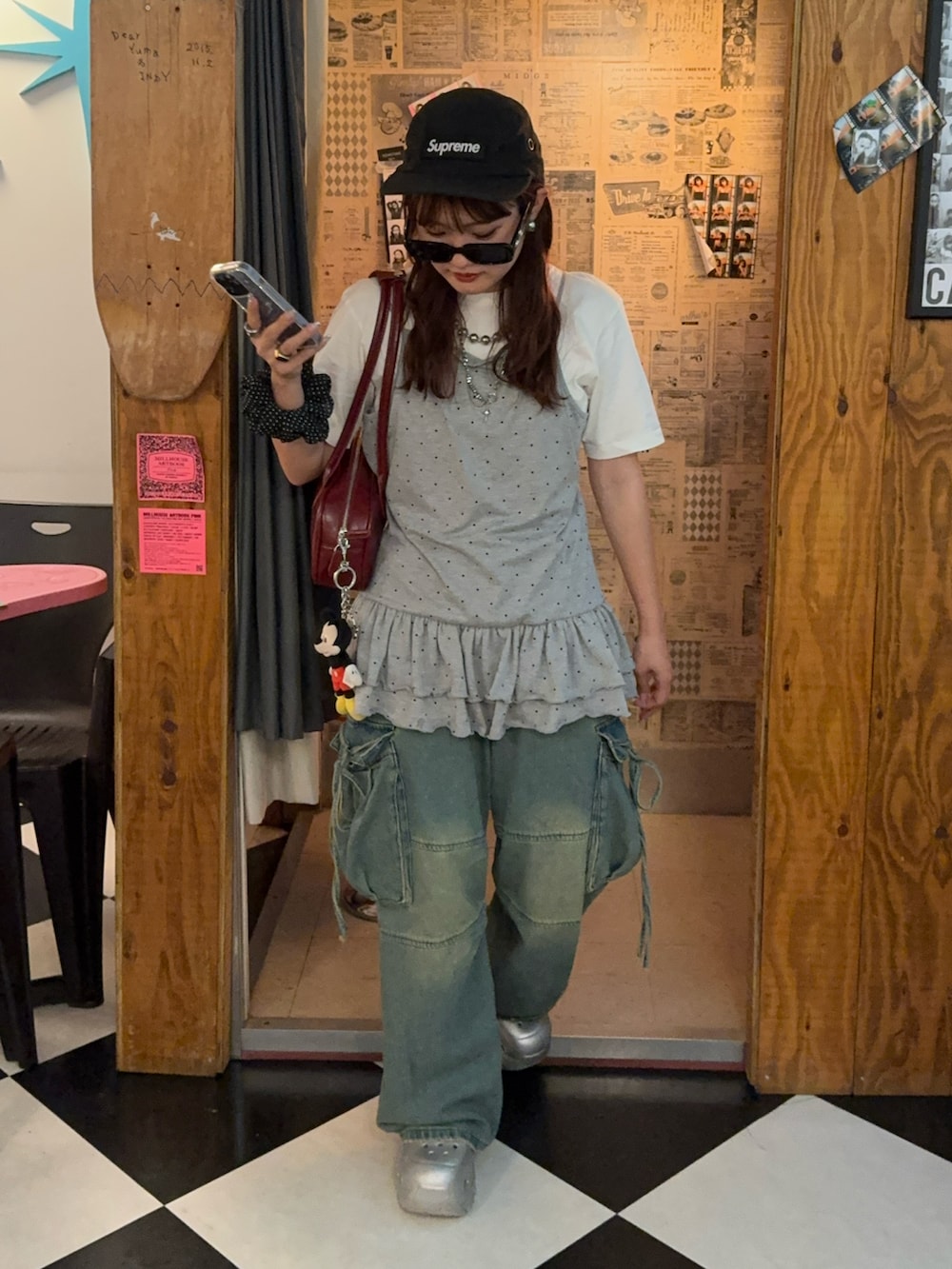 グレー系のキャミソール、ブルー系のデニムパンツ、シルバー系のサンダルを着用したレディースの夏コーディネートの2枚目の写真