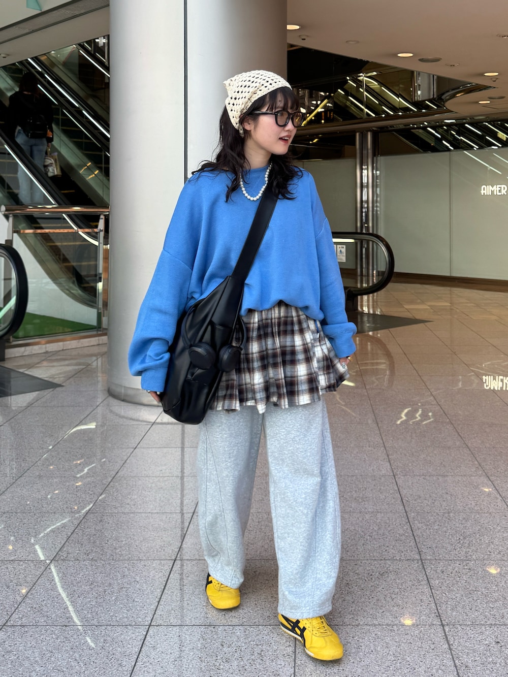 ブルー系のニット/セーター、グレー系のスウェットパンツ、イエロー系のスニーカーを着用したレディースの春コーディネートの2枚目の写真