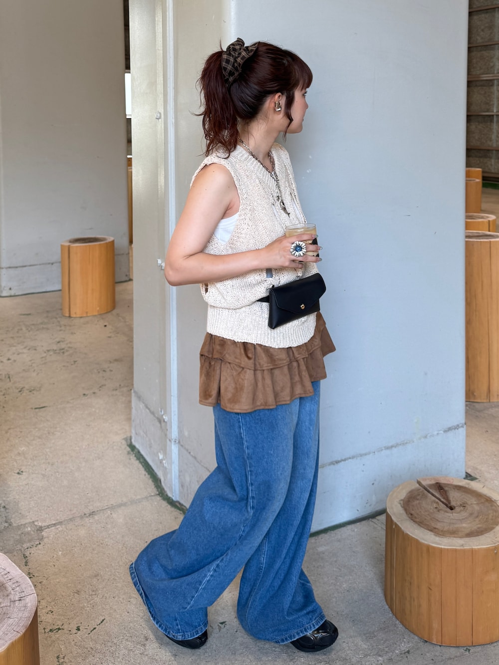 ホワイト系のベスト、ブルー系のデニムパンツ、ブラック系のボディバッグ/ウエストポーチを着用したレディースの夏コーディネートの2枚目の写真