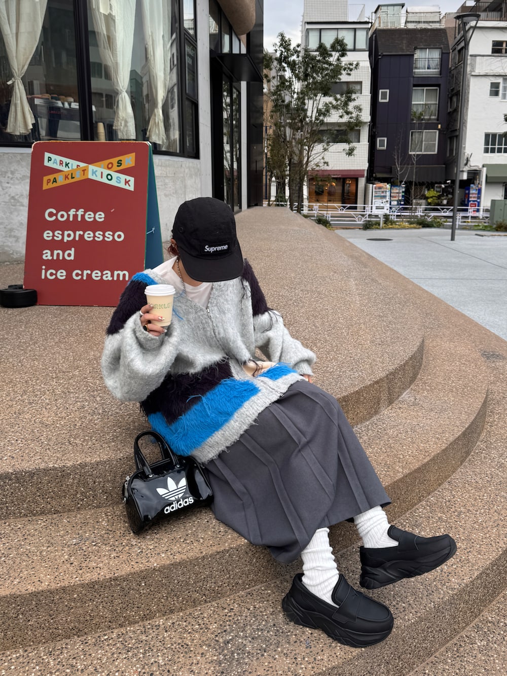 グレー系のカーディガン/ボレロ、グレー系のスカート、ブラック系のローファーを着用したレディースの冬コーディネートの2枚目の写真