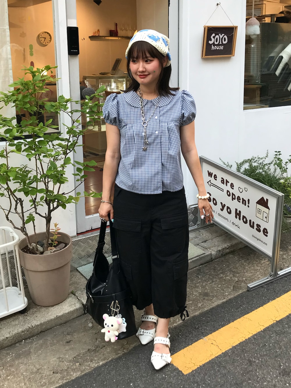 ブラック系のカーゴパンツ、ホワイト系のパンプス、ブルー系のシャツ/ブラウスを着用したレディースの夏コーディネートの2枚目の写真