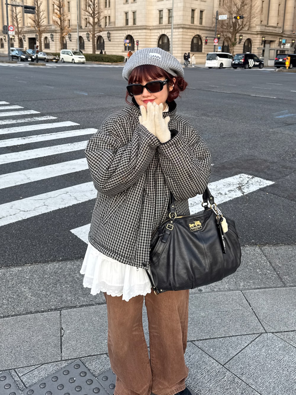 ブラック系のダウンジャケット/コート、ホワイト系のスカート、ブラウン系のデニムパンツを着用したレディースの冬コーディネートの2枚目の写真