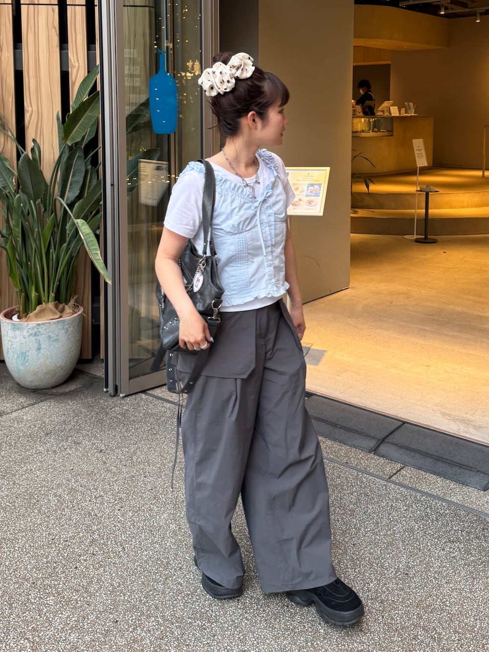 グレー系のトートバッグ、ブルー系のその他トップス、グレー系のパンツを着用したレディースの夏コーディネートの2枚目の写真