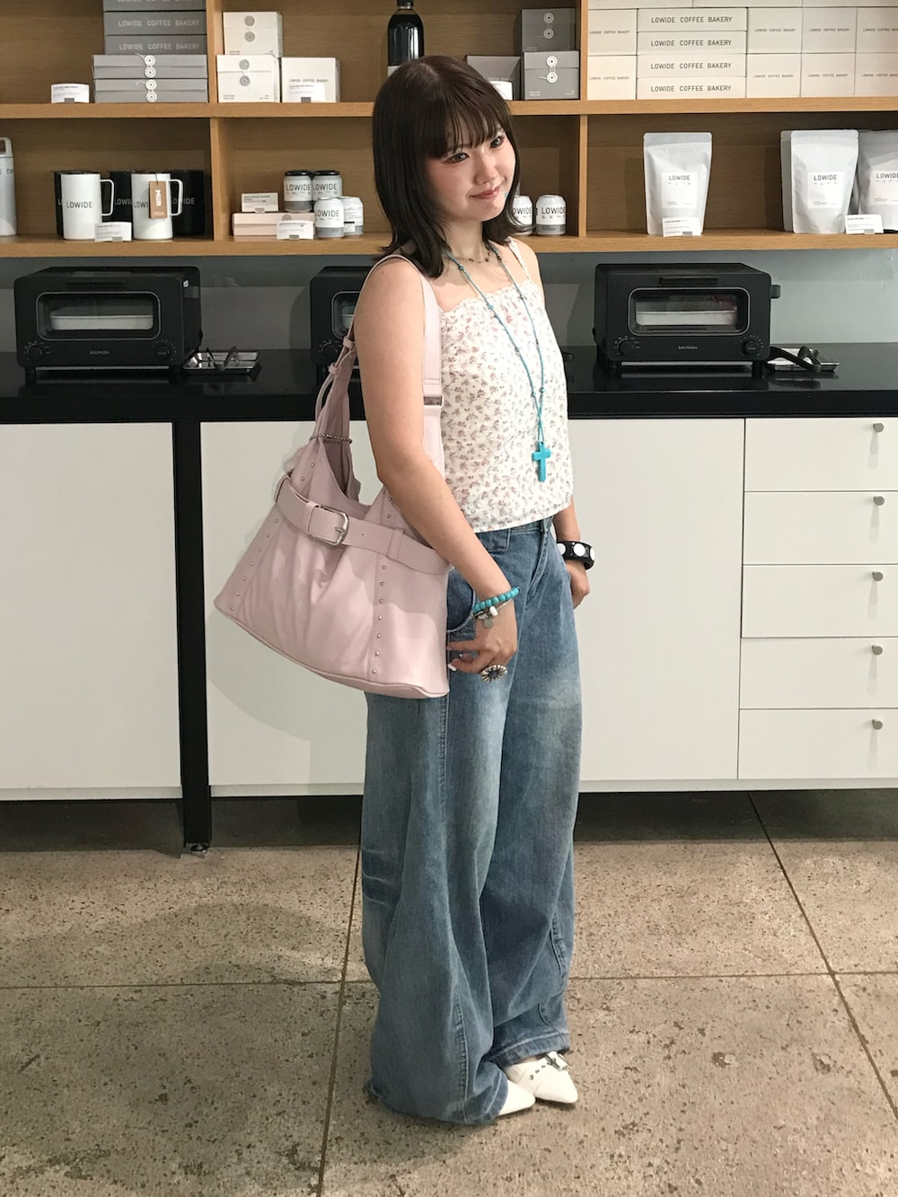 ホワイト系のパンプス、その他のキャミソール、ブルー系のデニムパンツを着用したレディースの夏コーディネートの2枚目の写真