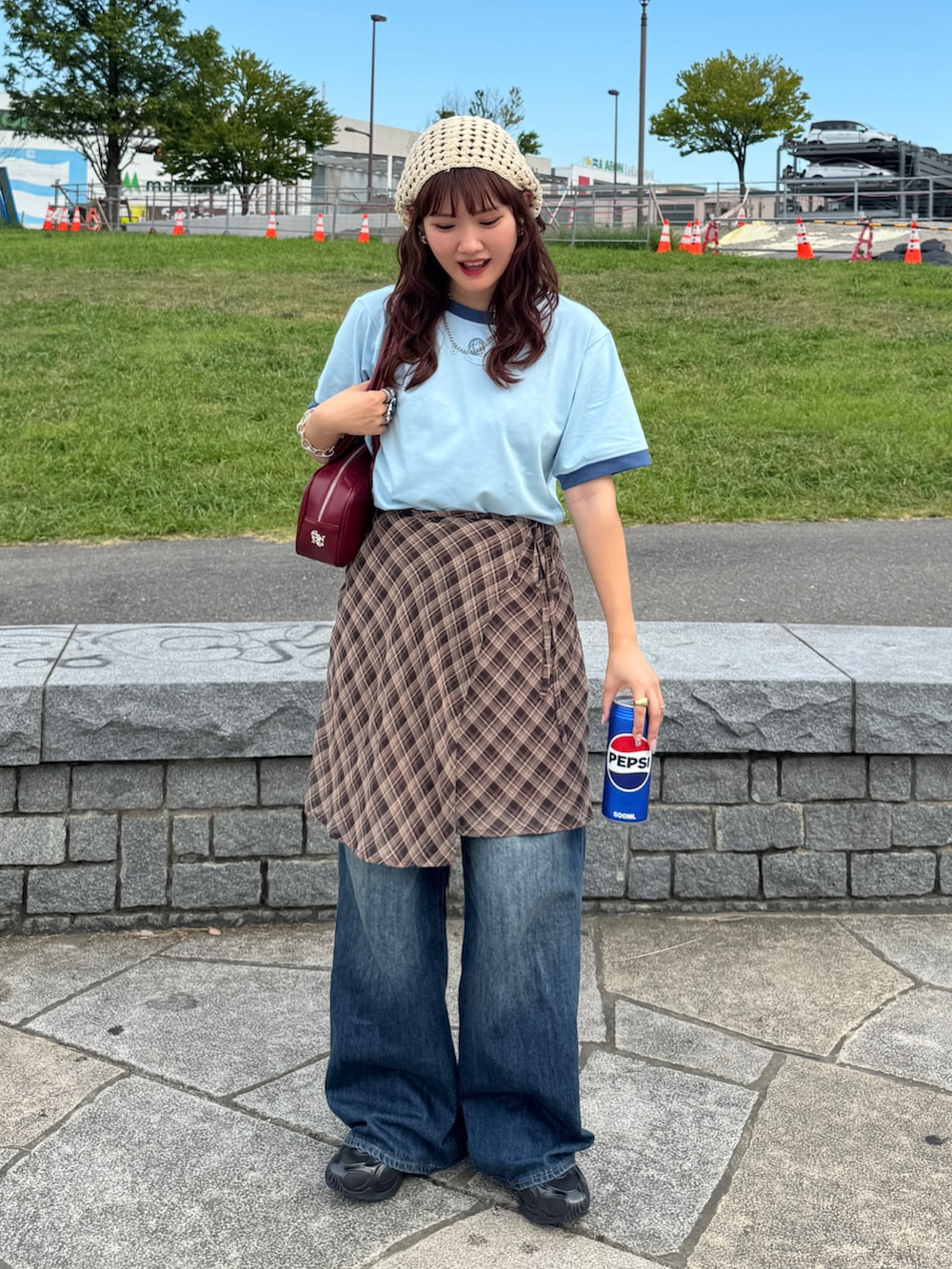 ブラック系のスニーカー、ブラウン系のスカート、ブルー系のデニムパンツを着用したレディースの夏コーディネートの2枚目の写真