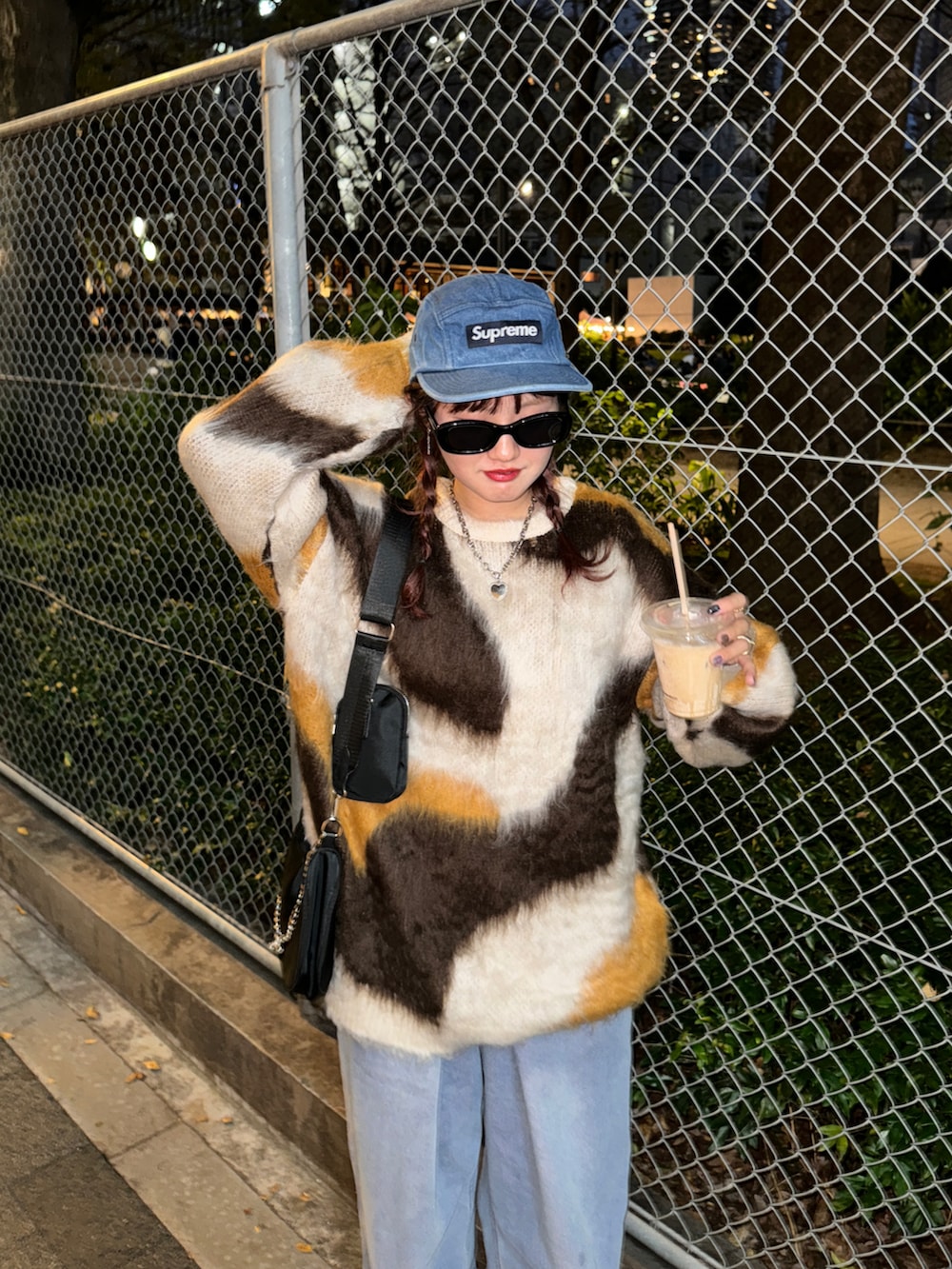 ブラウン系のニット/セーター、ブルー系のデニムパンツ、ブラウン系のスニーカーを着用したレディースの秋コーディネートの2枚目の写真