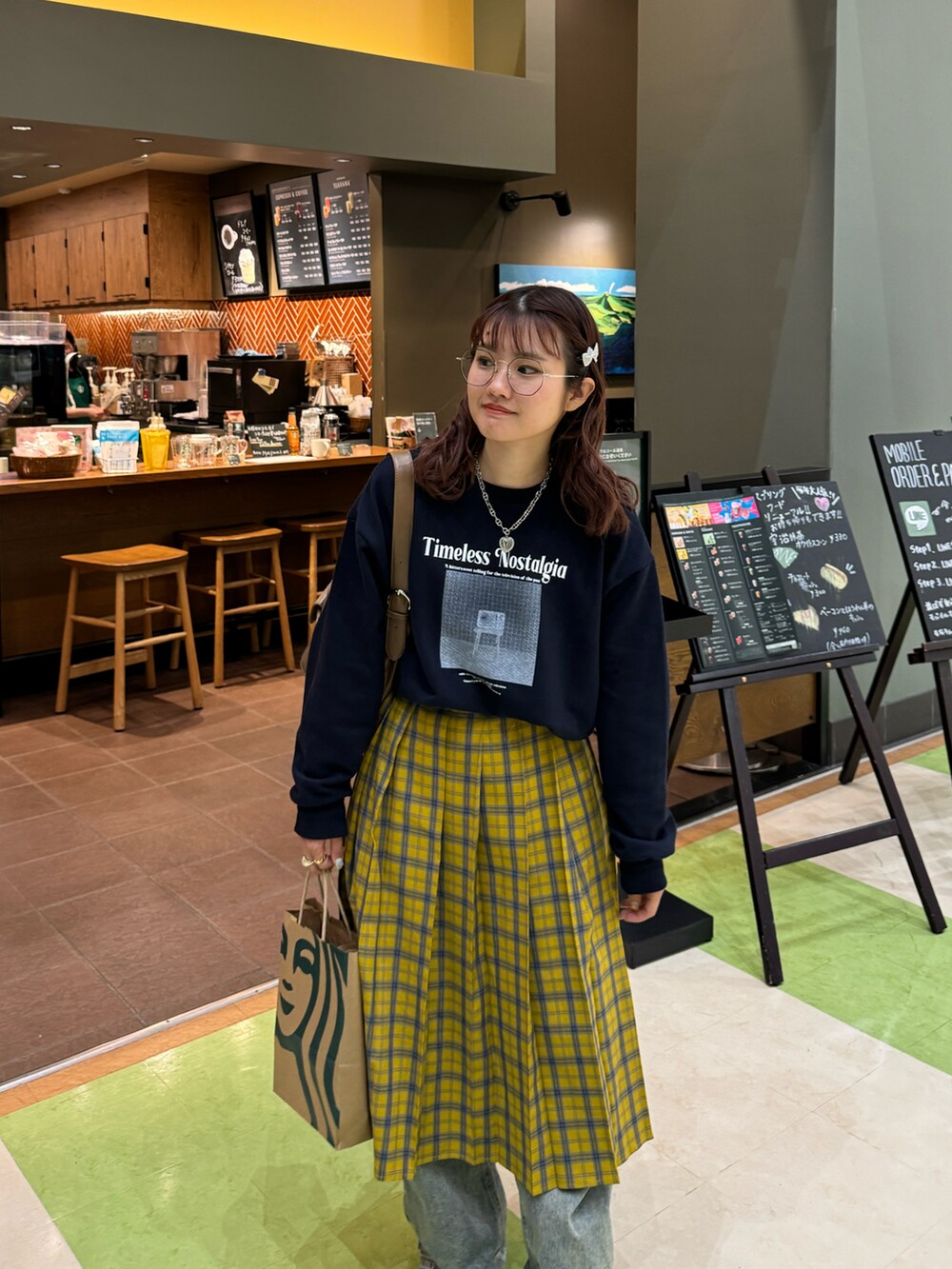 イエロー系のスカート、ブルー系のスウェット、ブルー系のスニーカーを着用したレディースの春コーディネートの2枚目の写真