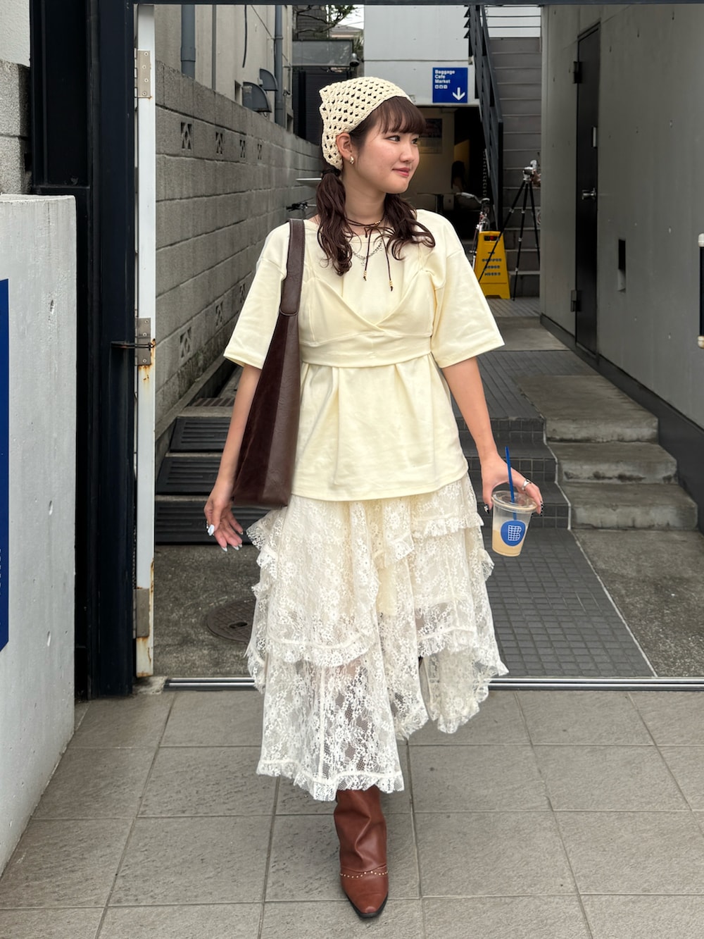 ホワイト系のスカート、ブラウン系のブーツ、イエロー系のTシャツ/カットソーを着用したレディースの春コーディネートの2枚目の写真