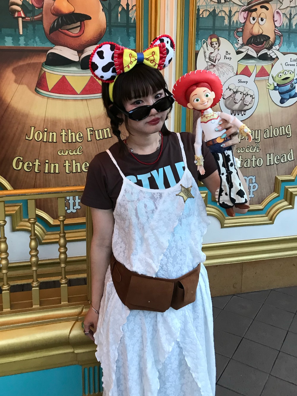 イエロー系のボディバッグ/ウエストポーチ、ブルー系のデニムパンツ、ブラウン系のTシャツ/カットソーを着用したレディースの夏コーディネートの2枚目の写真