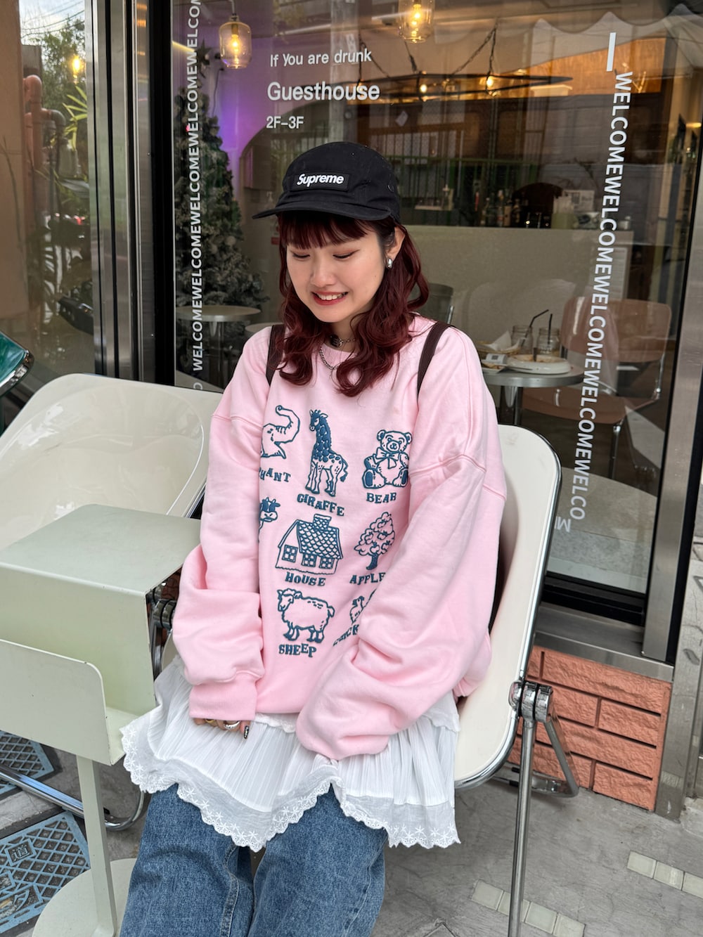 ピンク系のスウェット、ホワイト系のスカート、ブラック系のキャップを着用したレディースの冬コーディネートの2枚目の写真