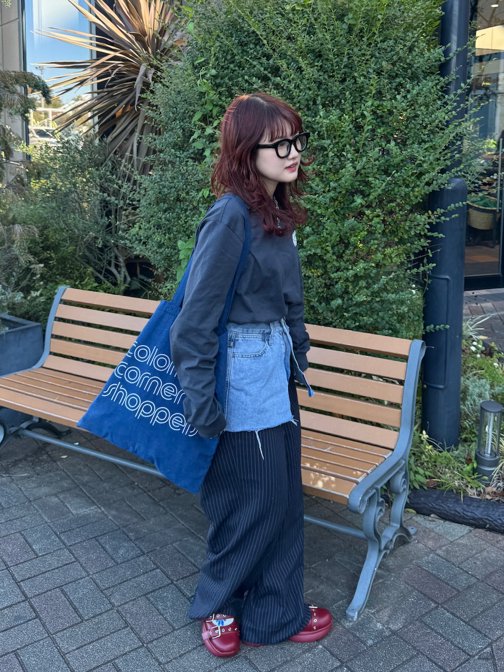 グレー系のTシャツ/カットソー、ブルー系のスラックスを着用したレディースの秋コーディネートの3枚目の写真