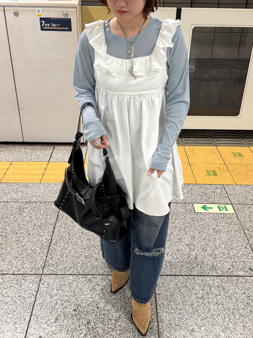 ブルー系のデニムパンツ、ブルー系のTシャツ/カットソー、ホワイト系のチュニックを着用したレディースの冬コーディネートの3枚目の写真