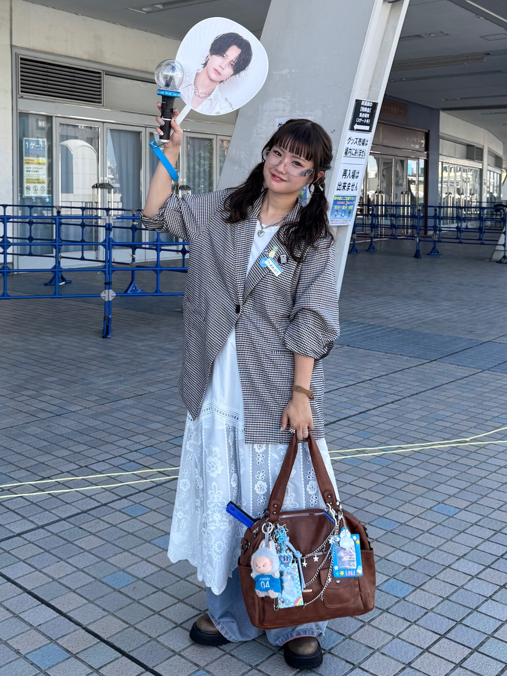 ブラック系のテーラードジャケット、ブルー系のデニムパンツ、ブラウン系のショルダーバッグを着用したレディースの秋コーディネートの2枚目の写真