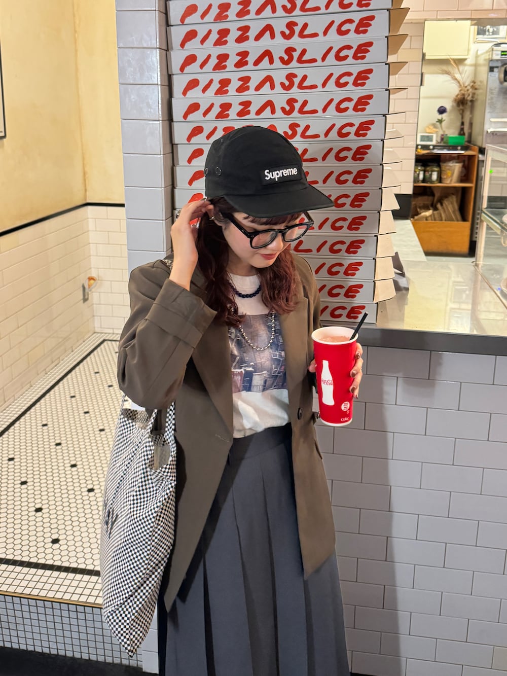 グレー系のスカート、ブラック系のスニーカー、ブラウン系のテーラードジャケットを着用したレディースの秋コーディネートの2枚目の写真