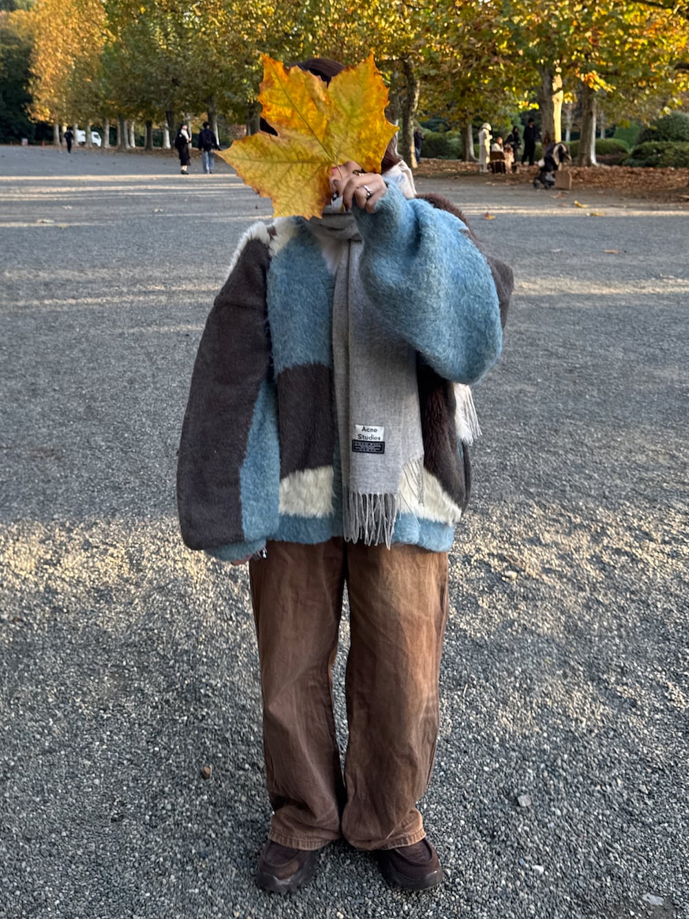 ブラウン系のデニムパンツ、ブルー系のニット/セーター、ブラウン系のローファーを着用したレディースの秋コーディネートの2枚目の写真