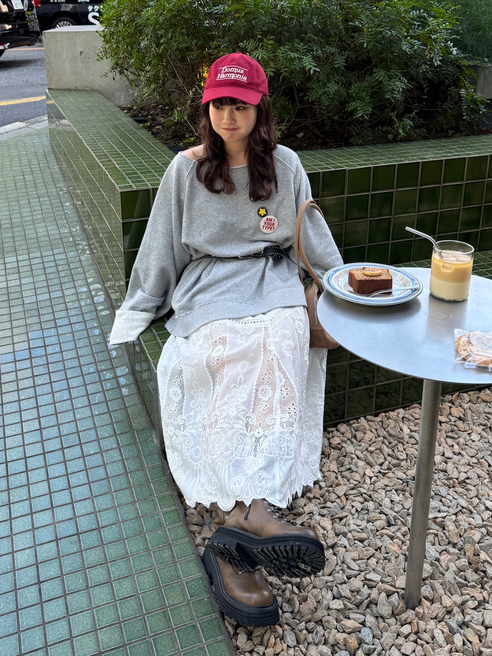 ベージュ系のボストンバッグ、グレー系のTシャツ/カットソー、ホワイト系のスカートを着用したレディースの秋コーディネートの3枚目の写真