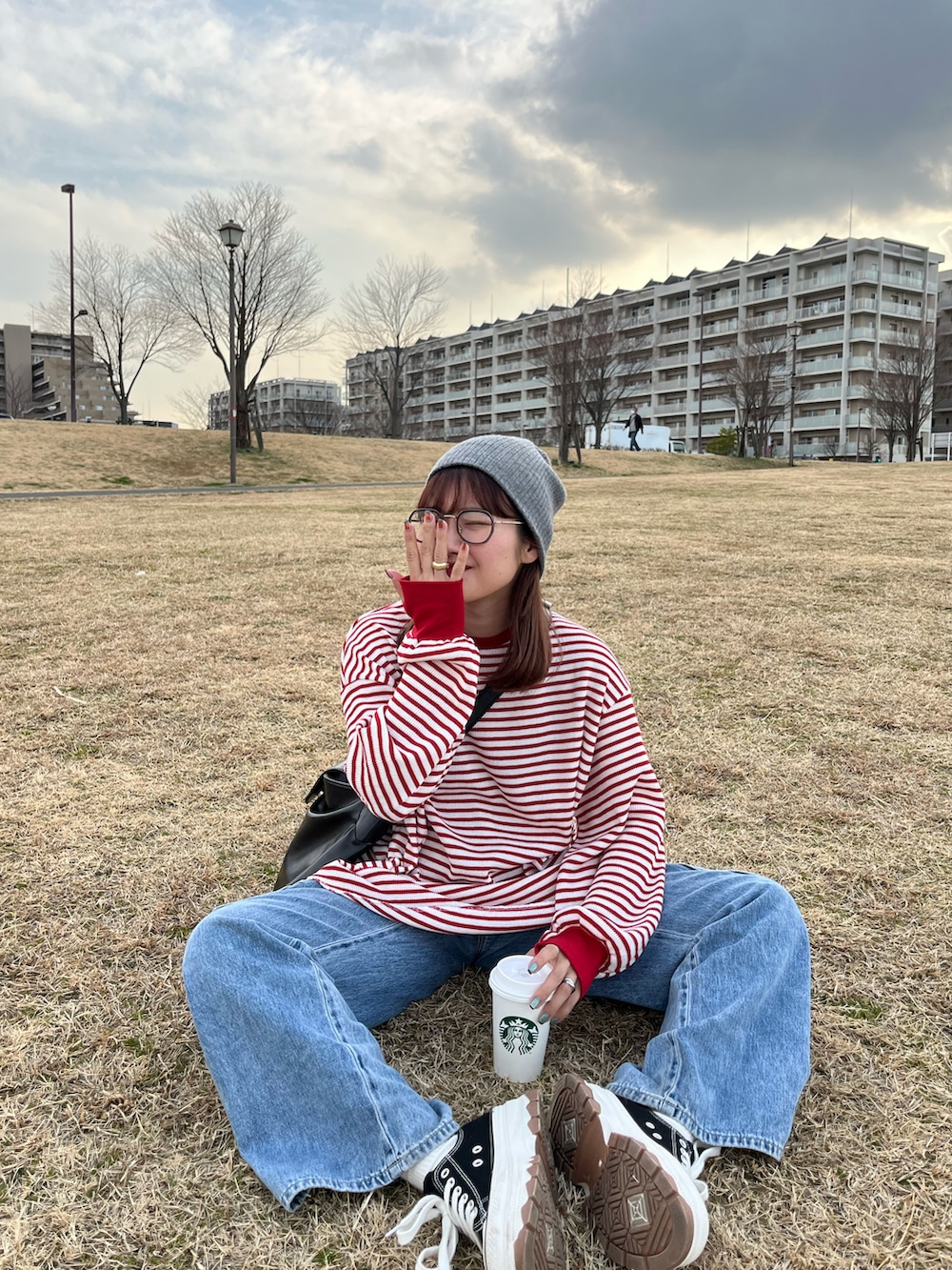 ブルー系のデニムパンツ、レッド系のTシャツ/カットソー、ブラック系のショルダーバッグを着用したレディースの冬コーディネートの2枚目の写真