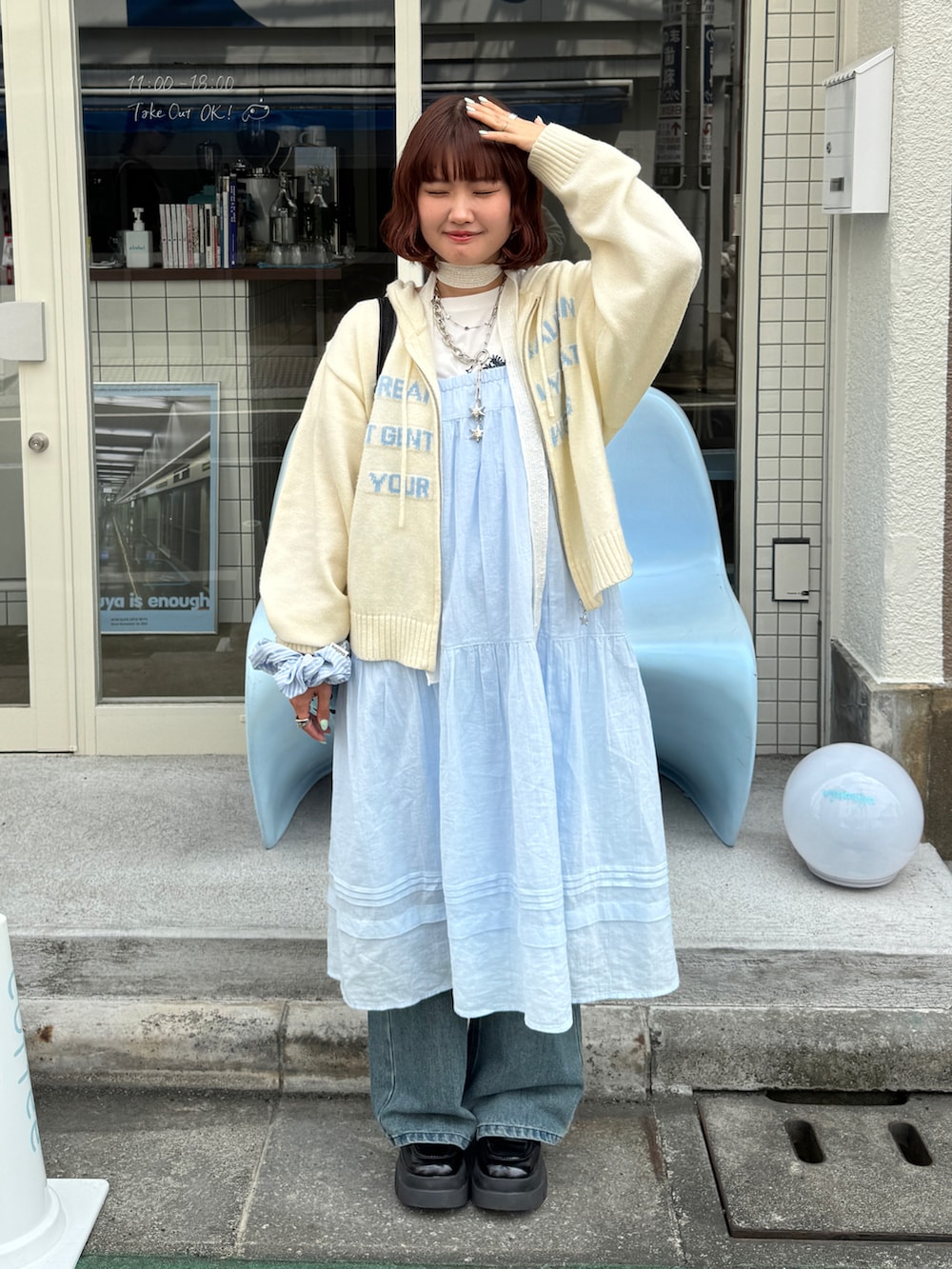 ブルー系のデニムパンツ、ブラック系のローファー、ホワイト系のニット/セーターを着用したレディースの春コーディネートの2枚目の写真