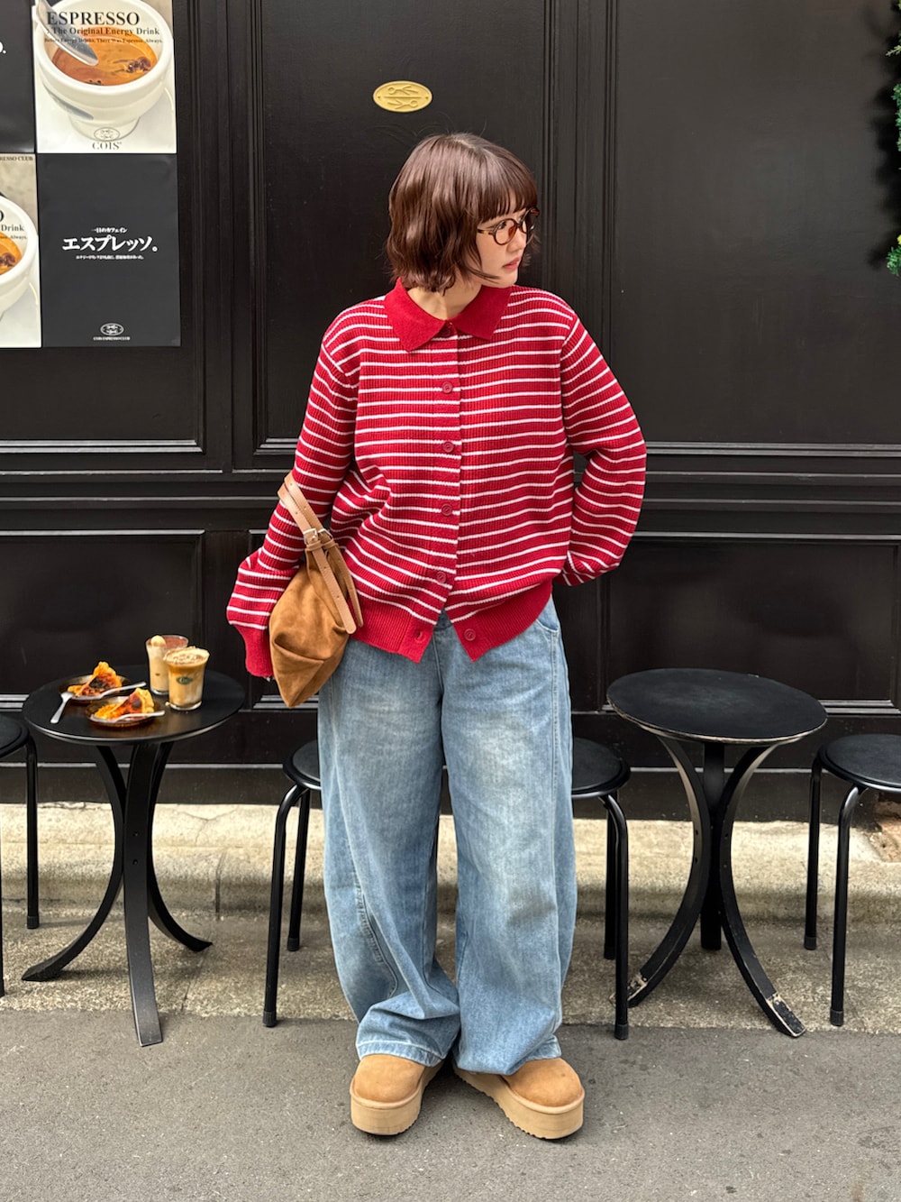 レッド系のニット/セーター、ブラウン系のブーツ、ブルー系のデニムパンツを着用したレディースの秋コーディネートの2枚目の写真