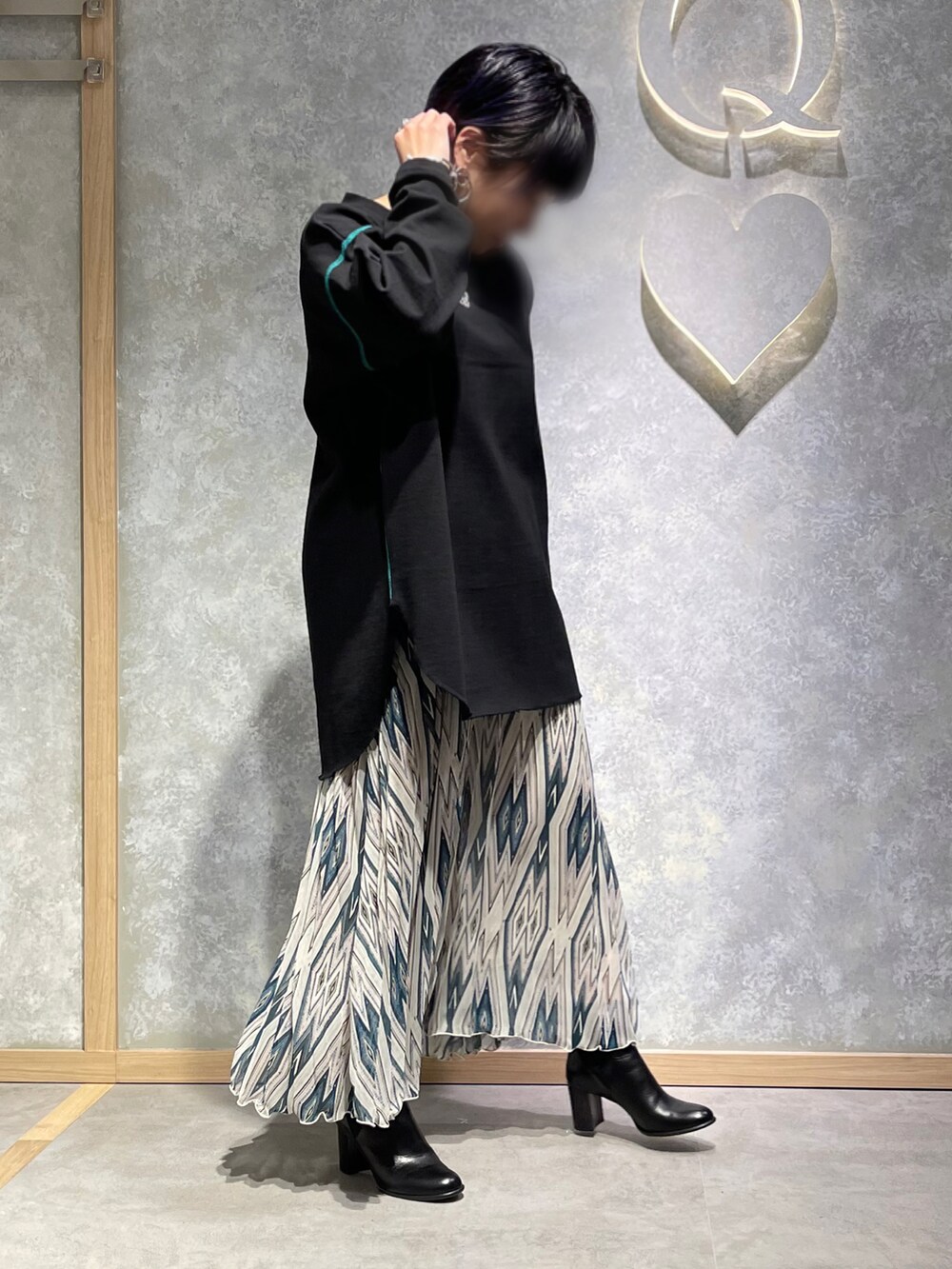 ブラック系のTシャツ/カットソー、オレンジ系のスカートを着用したレディースの冬コーディネートの2枚目の写真