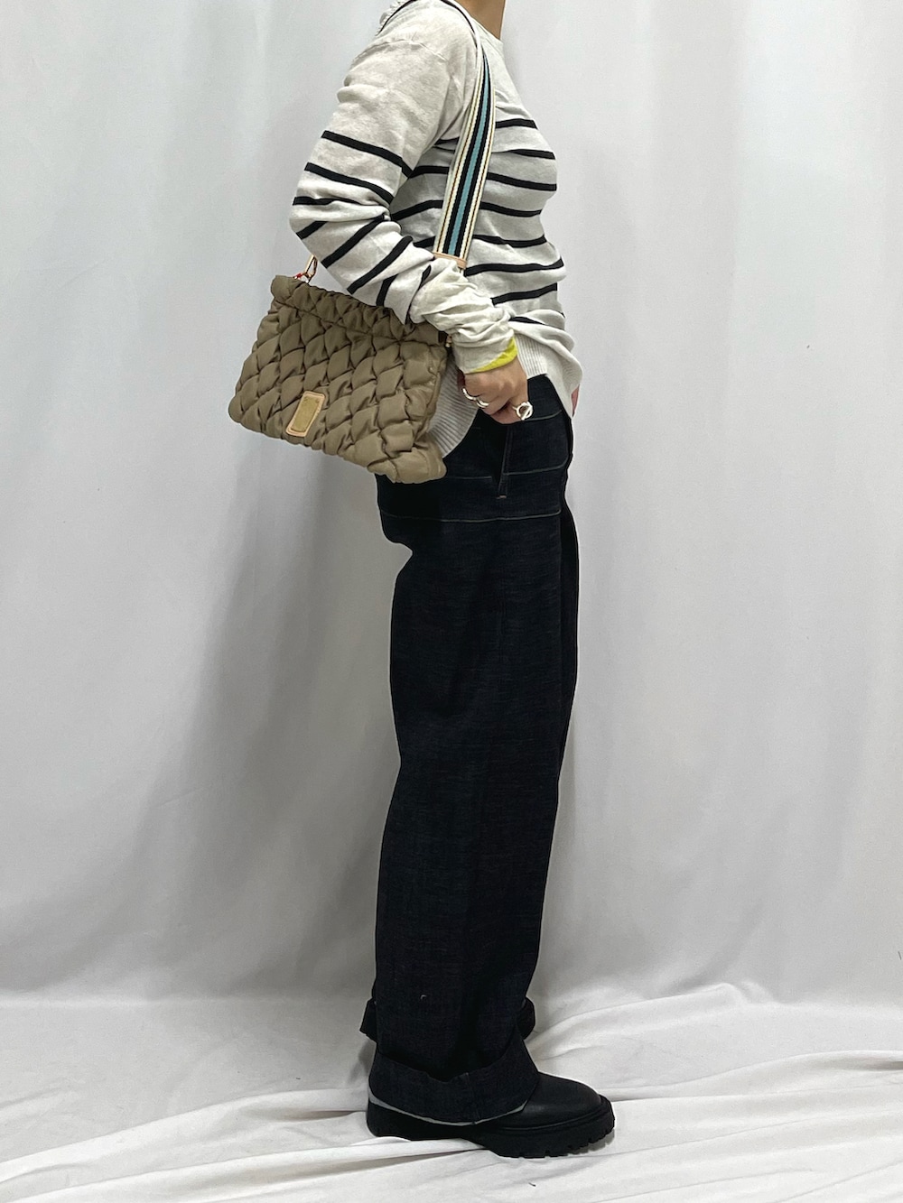 ベージュ系のショルダーバッグ、ホワイト系のニット/セーターを着用したレディースの秋コーディネートの2枚目の写真