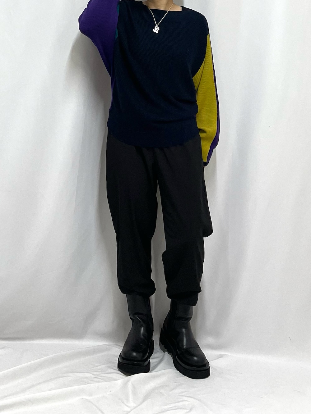 パープル系のニット/セーター、ブラック系のその他パンツを着用したレディースの秋コーディネートの2枚目の写真