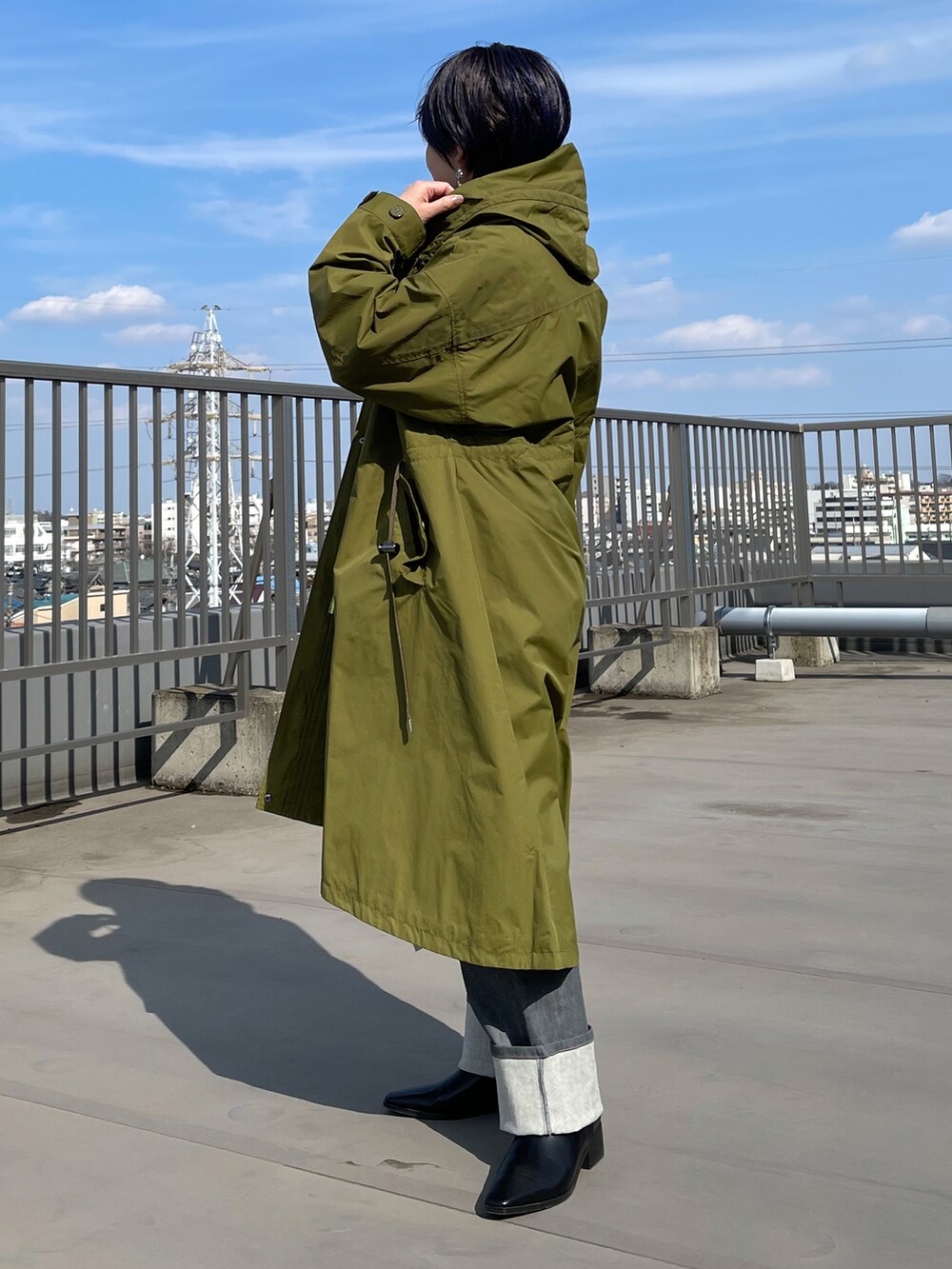 グリーン系のその他アウター、ベージュ系のワンピース、グレー系のデニムパンツを着用したレディースの春コーディネートの3枚目の写真