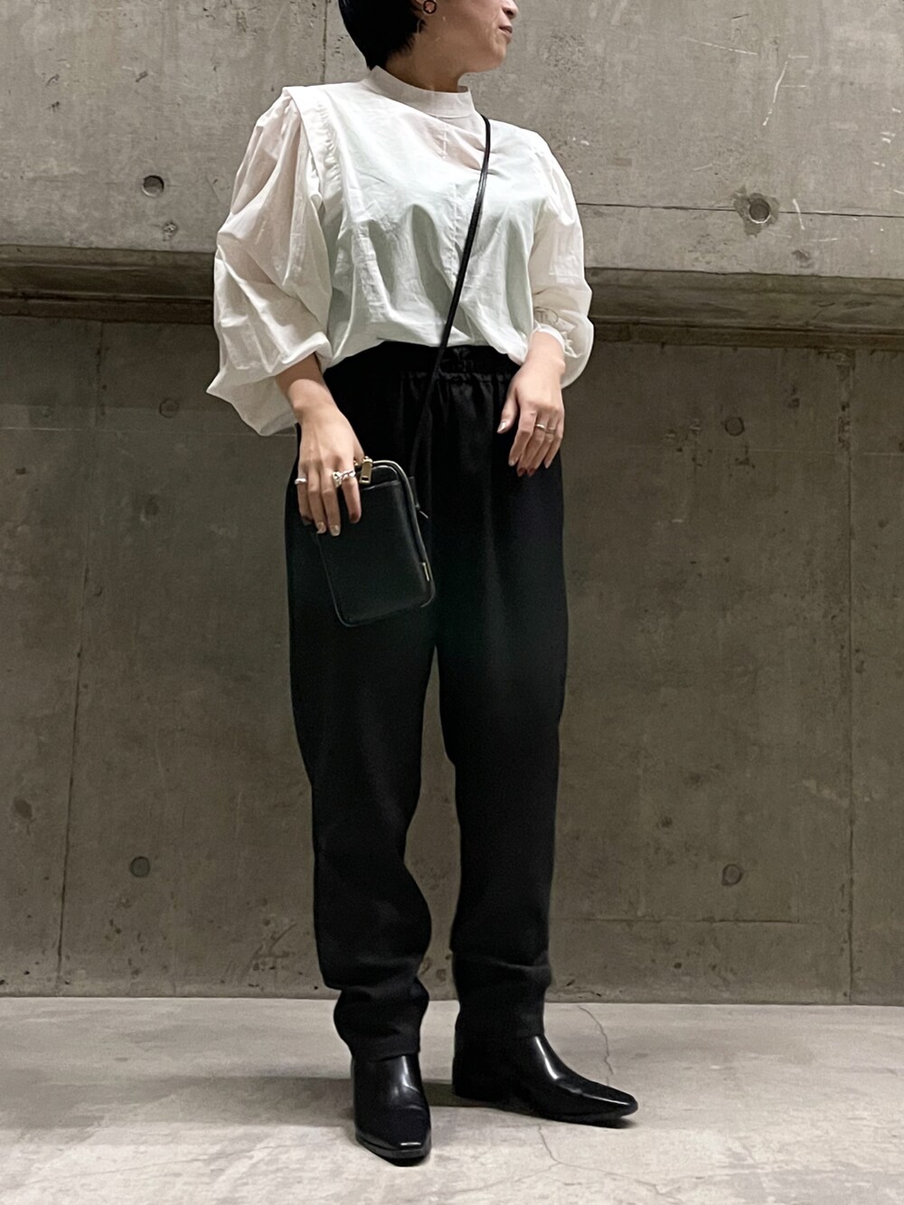ブラック系のその他パンツ、ブラック系のショルダーバッグ、ホワイト系のシャツ/ブラウスを着用したレディースの春コーディネートの2枚目の写真