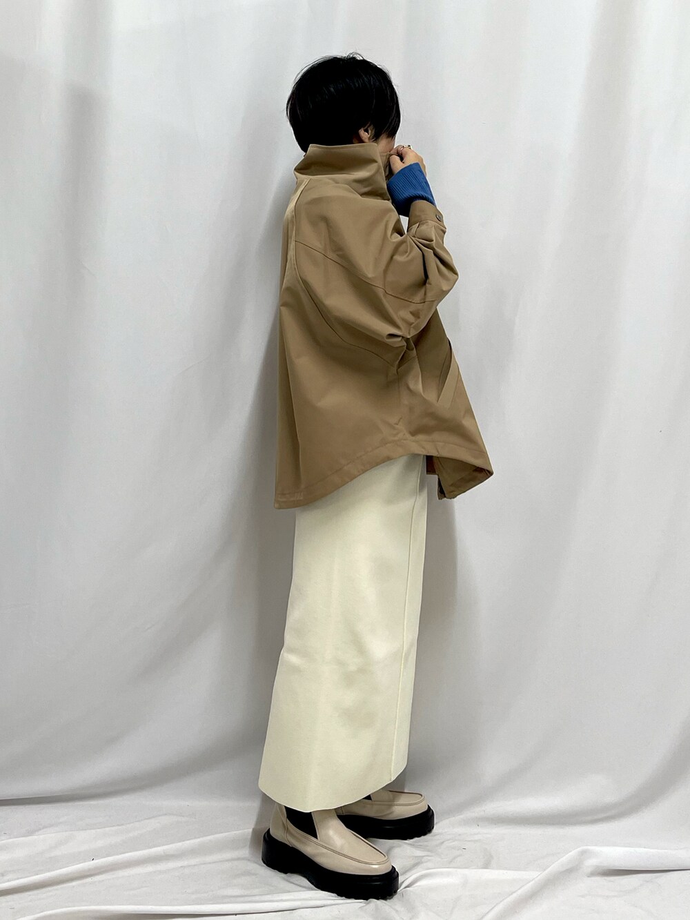 ホワイト系のブーツ、ホワイト系のスカート、イエロー系のブルゾンを着用したレディースの秋コーディネートの2枚目の写真