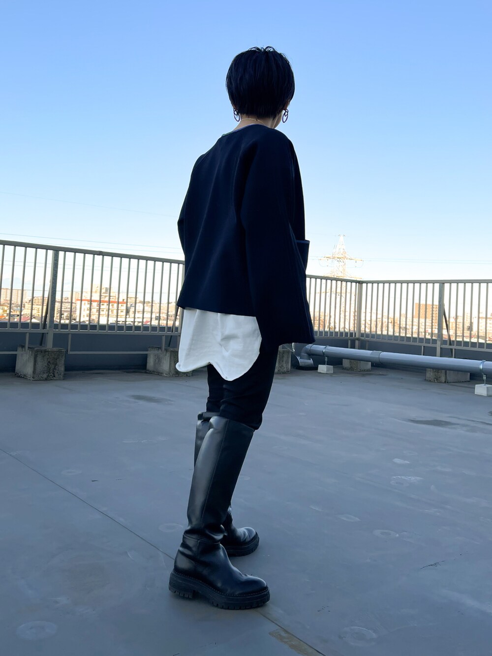 ブルー系のカーディガン/ボレロ、ブラック系のデニムパンツ、ホワイト系のTシャツ/カットソーを着用したレディースの冬コーディネートの2枚目の写真