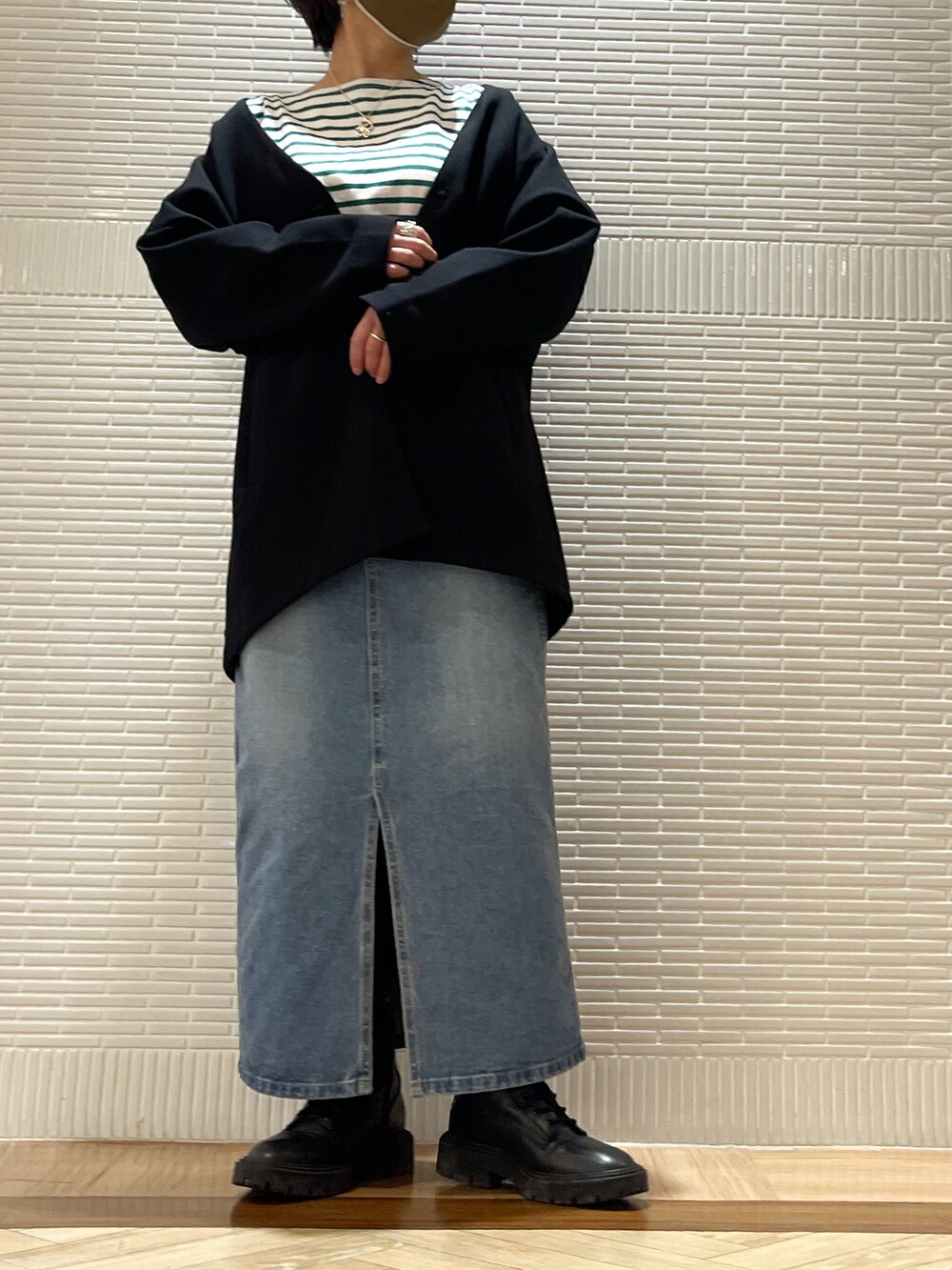 ブルー系のデニムスカート、ブラック系のブーツ、ブルー系のTシャツ/カットソーを着用したレディースの冬コーディネートの2枚目の写真