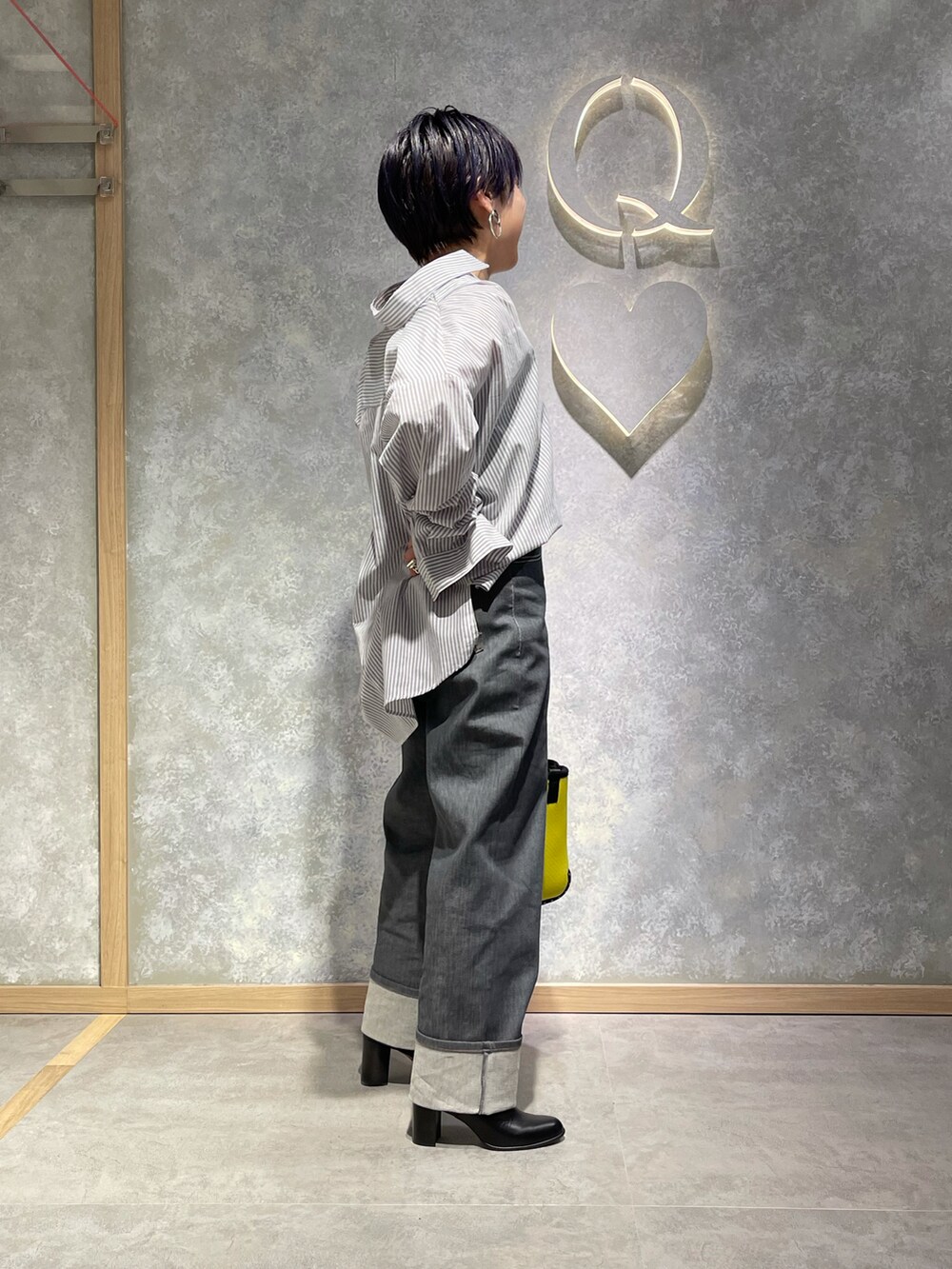 ホワイト系のシャツ/ブラウス、グリーン系のトートバッグ、グレー系のデニムパンツを着用したレディースの春コーディネートの2枚目の写真