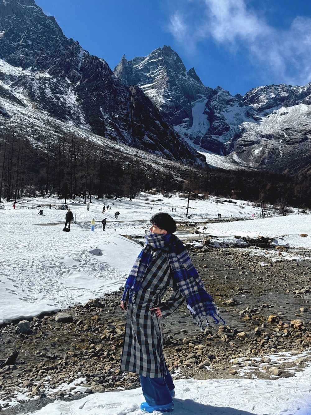 ブラック系のトレンチコート、ブルー系のマフラーを着用したメンズの春コーディネートの3枚目の写真