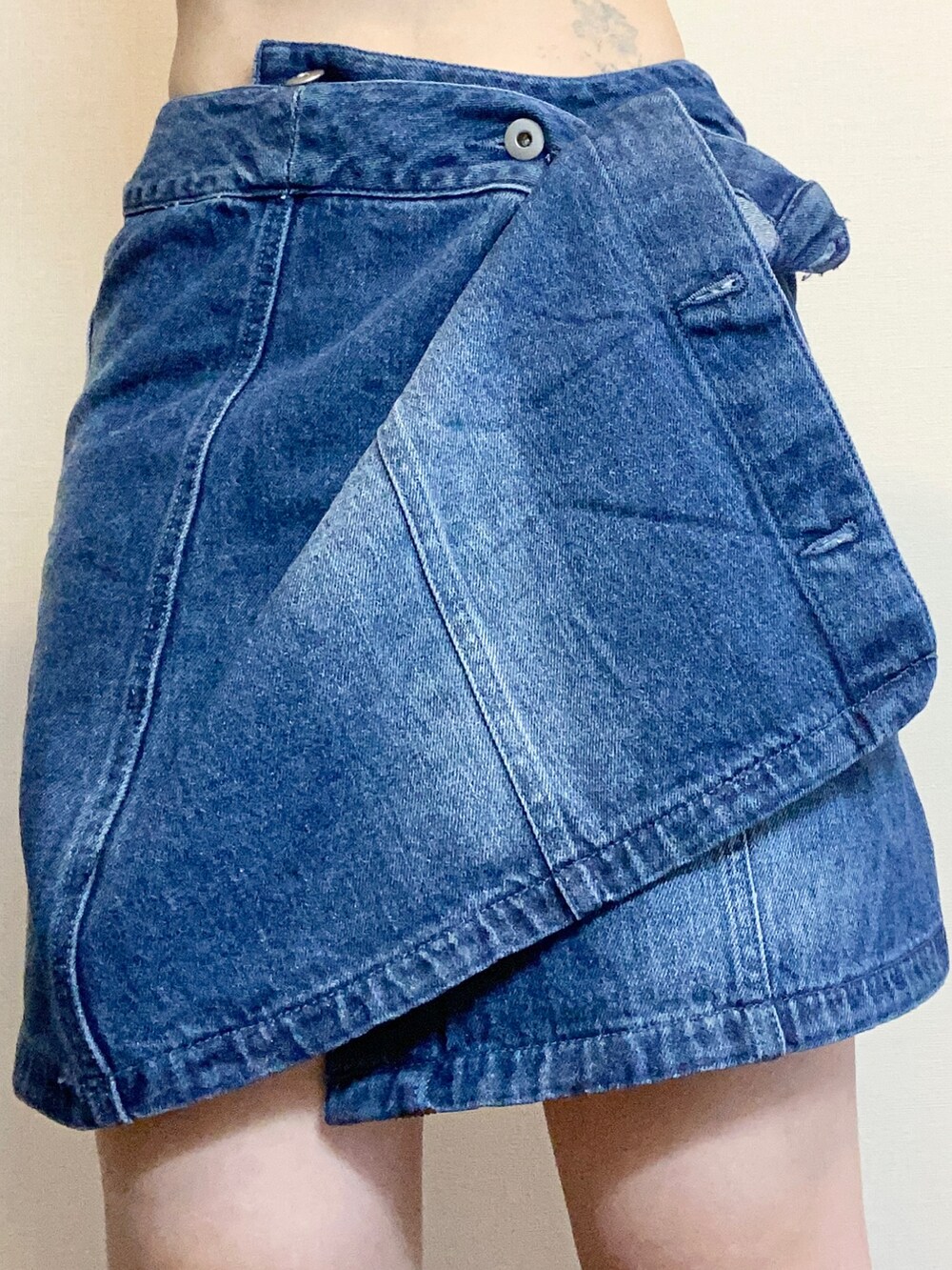 ホワイト系のスニーカー、ブルー系のデニムジャケット、シルバー系のピアス（両耳用）を着用したレディースの秋コーディネートの3枚目の写真