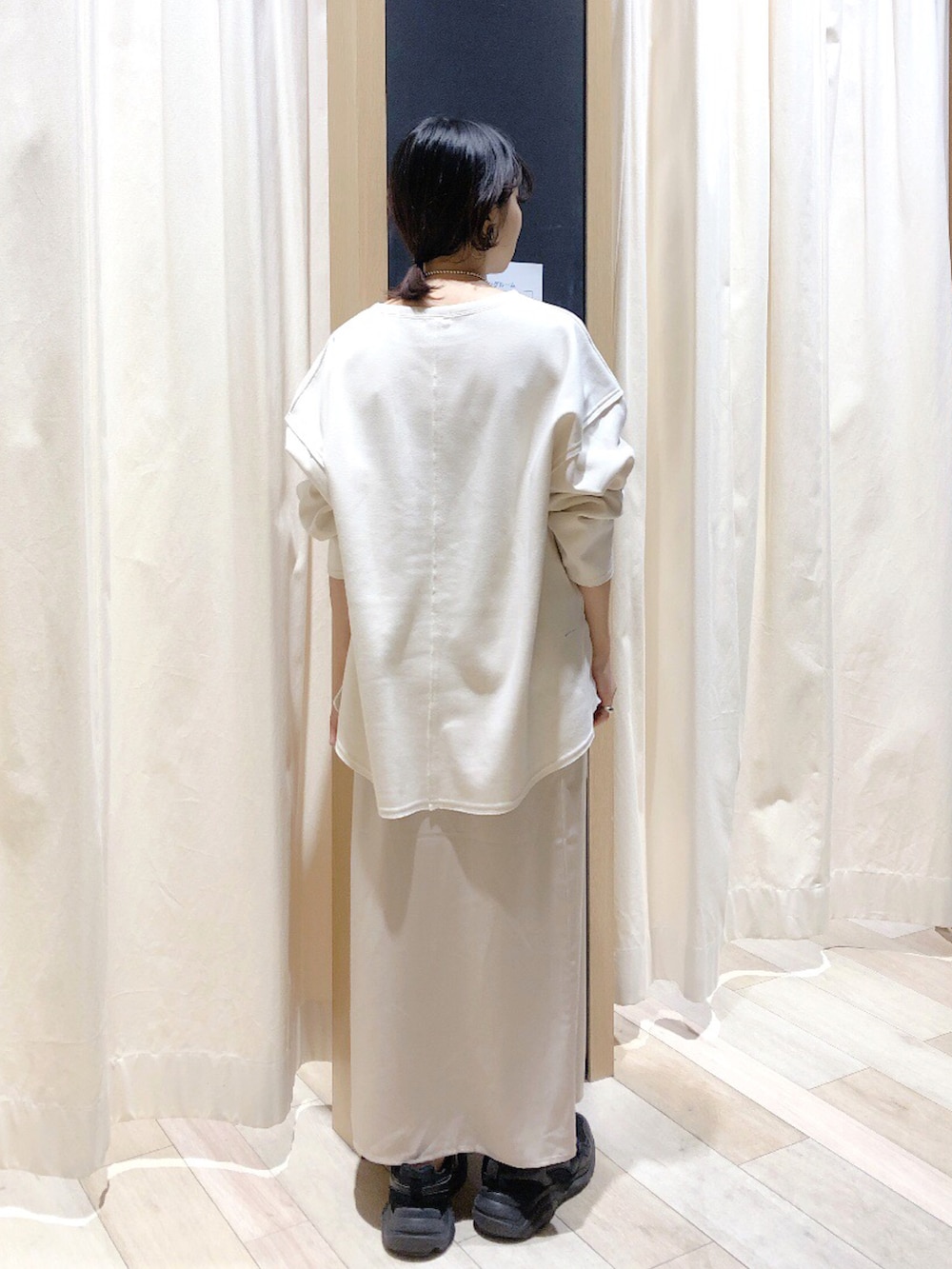 ホワイト系のTシャツ/カットソー、ベージュ系のスカート、レッド系のトップスを着用したレディースの冬コーディネートの4枚目の写真