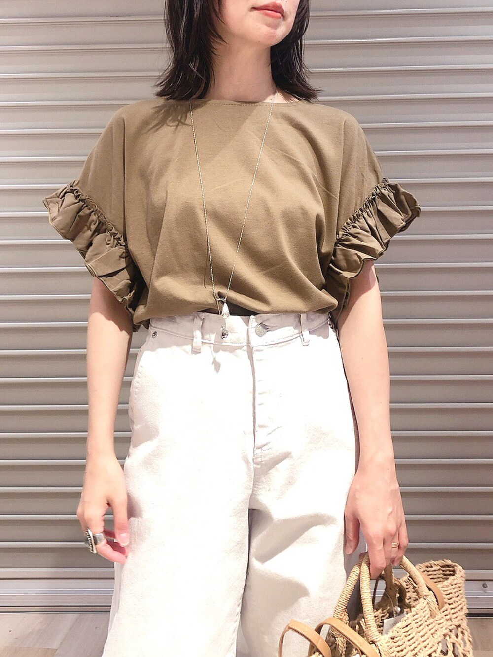 グリーン系のTシャツ/カットソー、ベージュ系のデニムパンツ、ブラック系のサンダルを着用したレディースの夏コーディネートの3枚目の写真