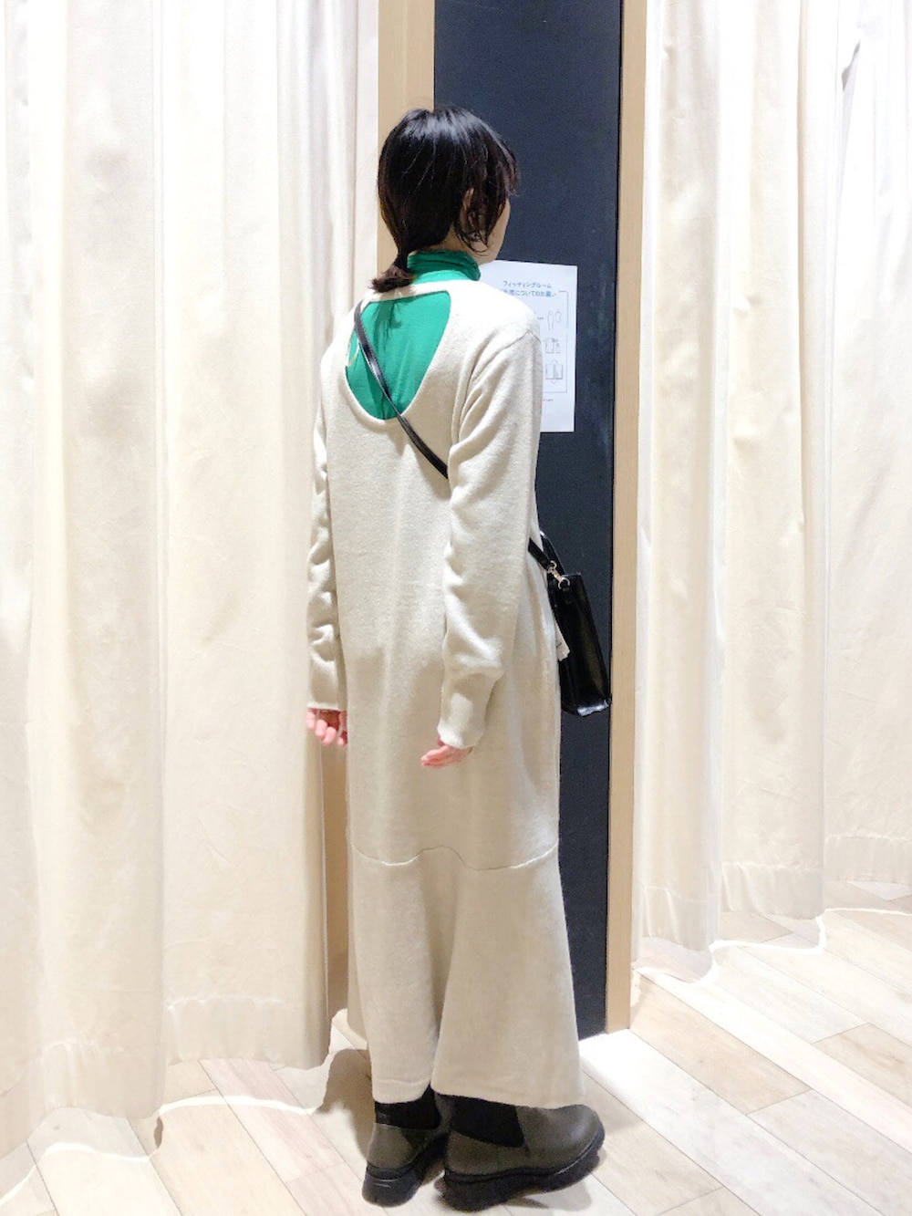 グリーン系のブーツ、ブラック系のショルダーバッグ、グリーン系のTシャツ/カットソーを着用したレディースの冬コーディネートの3枚目の写真