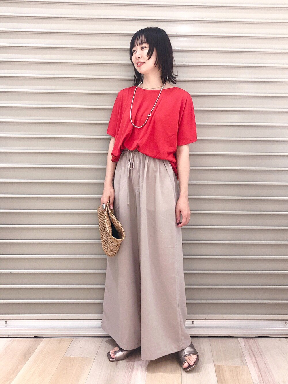 レッド系のTシャツ/カットソー、ベージュ系のその他パンツ、その他のサンダルを着用したレディースの春コーディネートの2枚目の写真