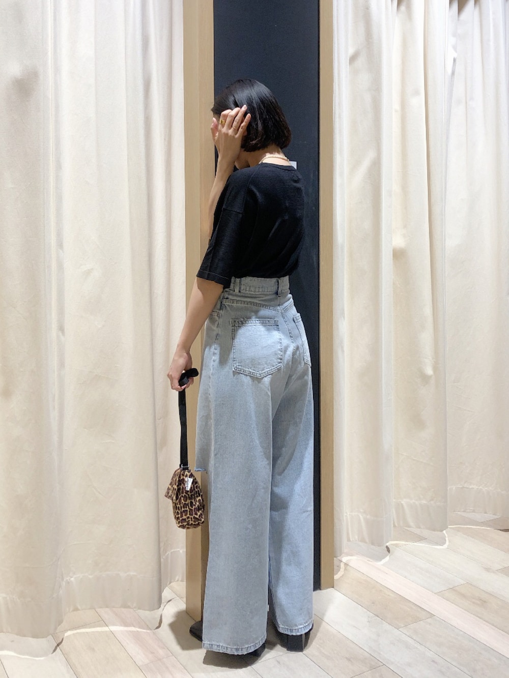 ブラック系のサンダル、ブルー系のデニムパンツ、ブラック系のニット/セーターを着用したレディースの春コーディネートの3枚目の写真