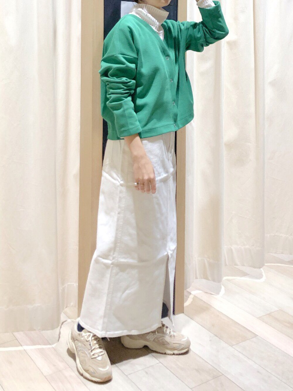 グリーン系のカーディガン/ボレロ、ホワイト系のTシャツ/カットソー、ホワイト系のデニムスカートを着用したレディースの冬コーディネートの3枚目の写真