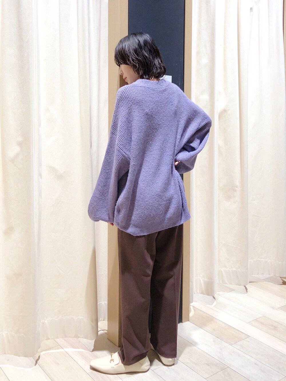 パープル系のニット/セーター、ブラウン系のスラックス、ホワイト系のローファーを着用したレディースの秋コーディネートの4枚目の写真