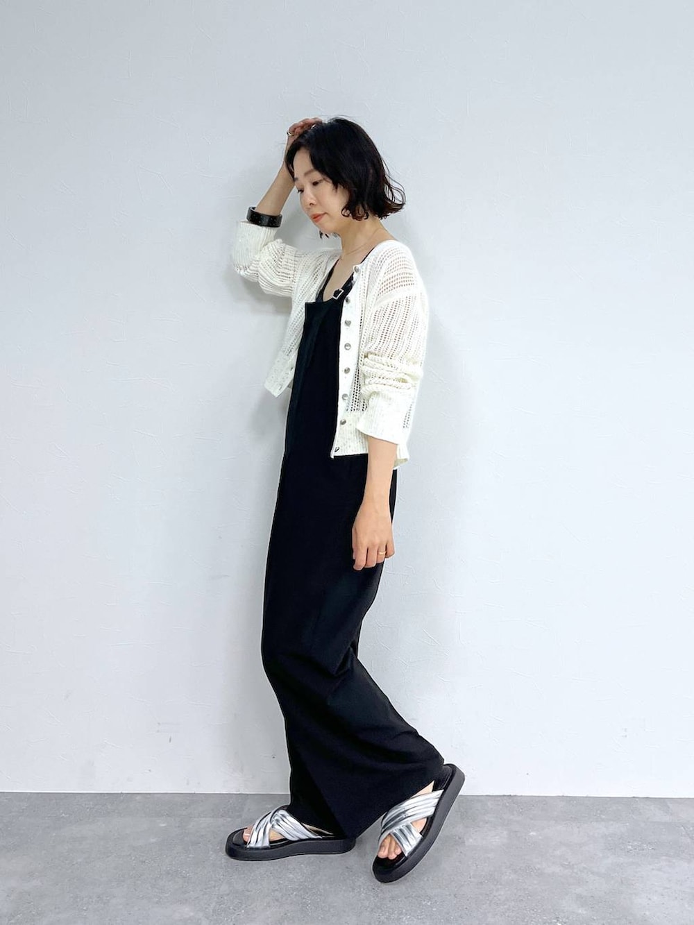 ホワイト系のカーディガン/ボレロ、シルバー系のサンダル、ブラック系のサロペット/オーバーオールを着用したレディースの夏コーディネートの2枚目の写真