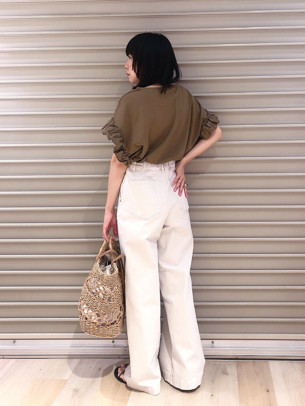 グリーン系のTシャツ/カットソー、ベージュ系のデニムパンツ、ブラック系のサンダルを着用したレディースの夏コーディネートの2枚目の写真